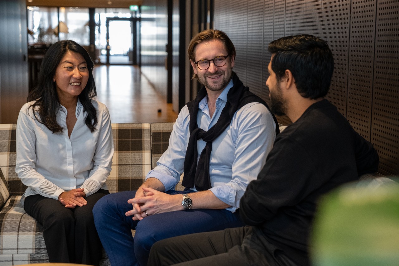 three people, the one at the left and in the middle is miling to the one at the right. 